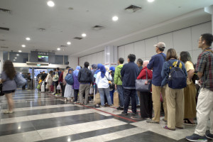 Empty desks and microscopes in a university lab with “Out of Office – Visa Delayed” note on the workstation.