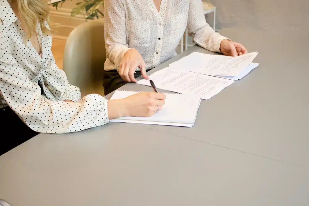 Form I-290B Lawyer: Motions to Reopen or Reconsider 2 Two people reviewing and signing documents at a table.