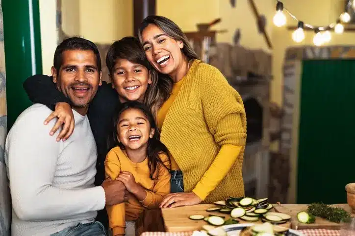 Parents and two children standing together at a kitchen counter